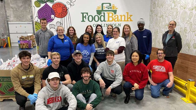 Students pose in front of Food Bank of Lincoln mural.